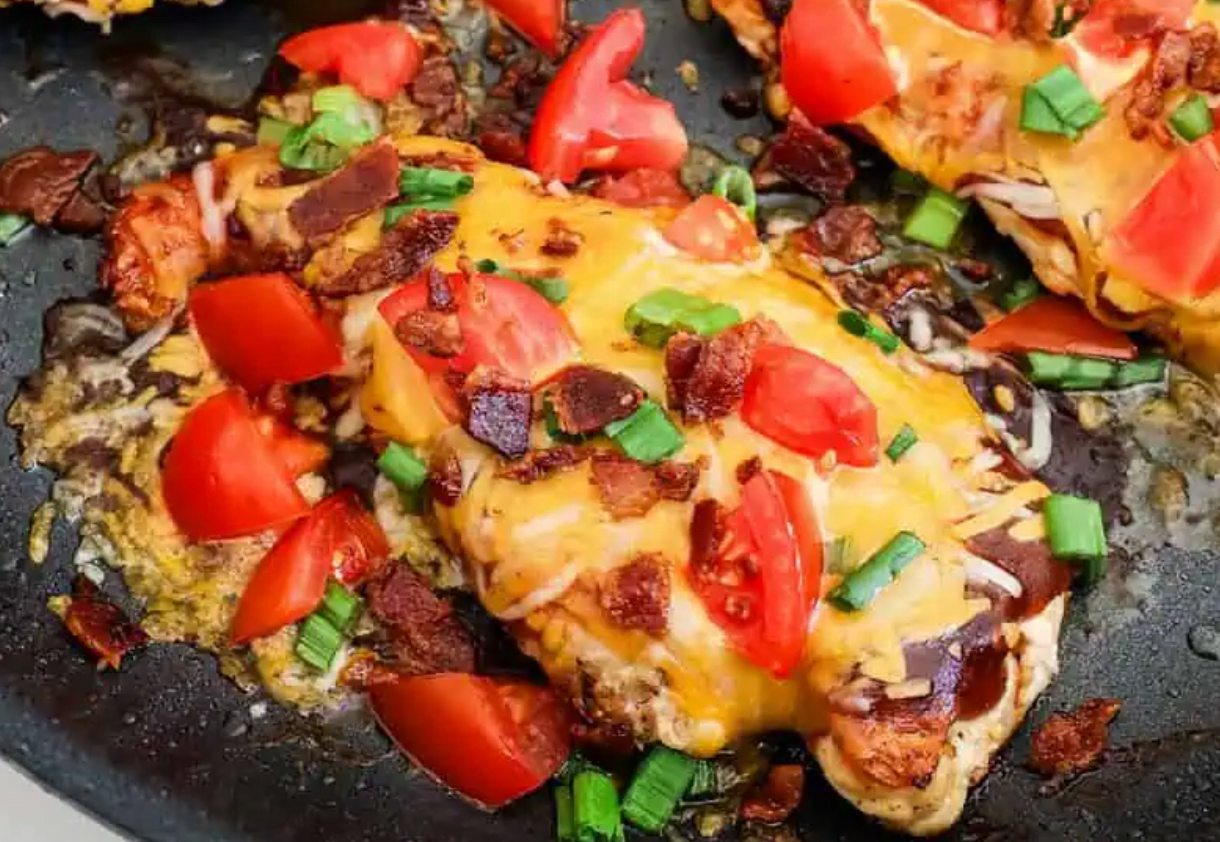 1 tablespoon olive oil 4 thin boneless skinless chicken breasts or 2 thick ones cut in half lengthwise kosher salt freshly ground black pepper 1/2 cup barbecue sauce use your favorite brand 1 cup Monterey Jack and cheddar blend 4 slices bacon cooked and crumbled 1/2 cup finely diced tomatoes 1 green onion thinly sliced